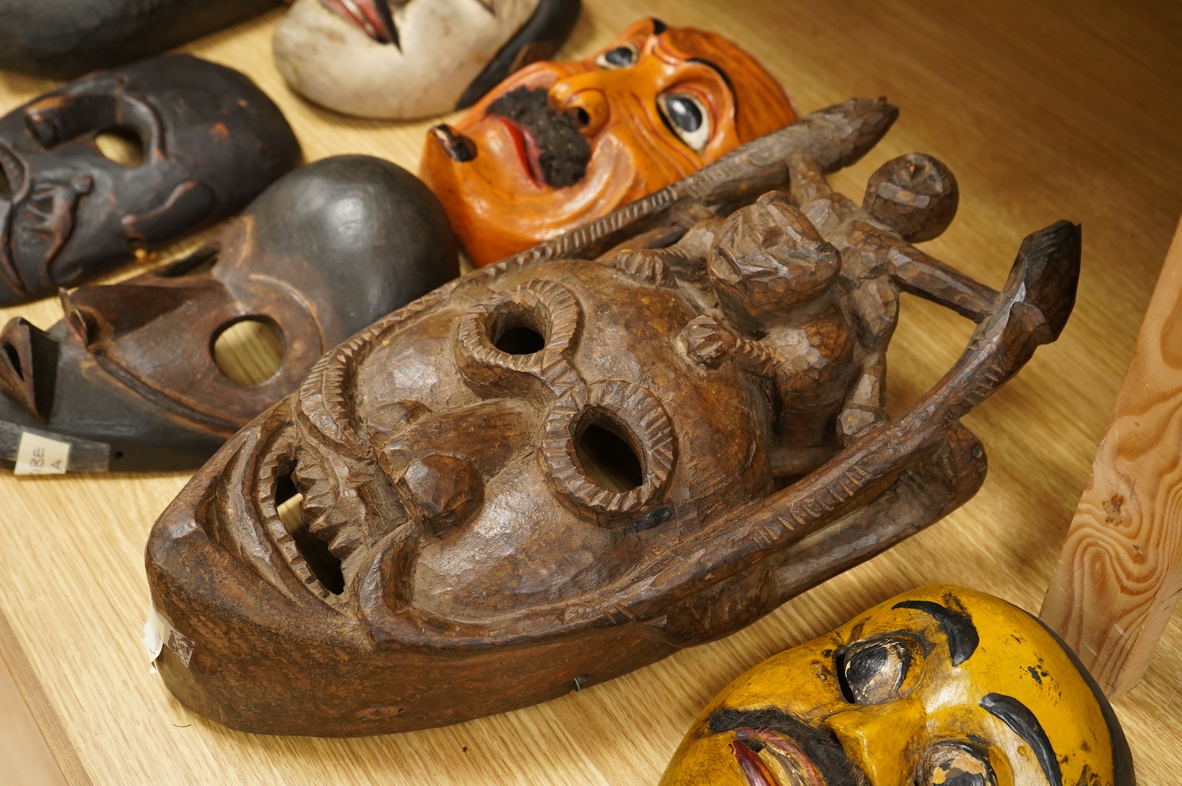 A collection of seven Nepalese, African and Indonesian masks to include a Magar example and one from the Dan Tribe, Liberia, largest 40cm